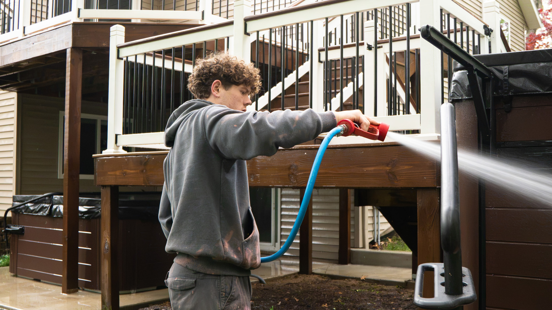 Elevation crew soft-washing a home, deck, and railing in the Grand Rapids metro