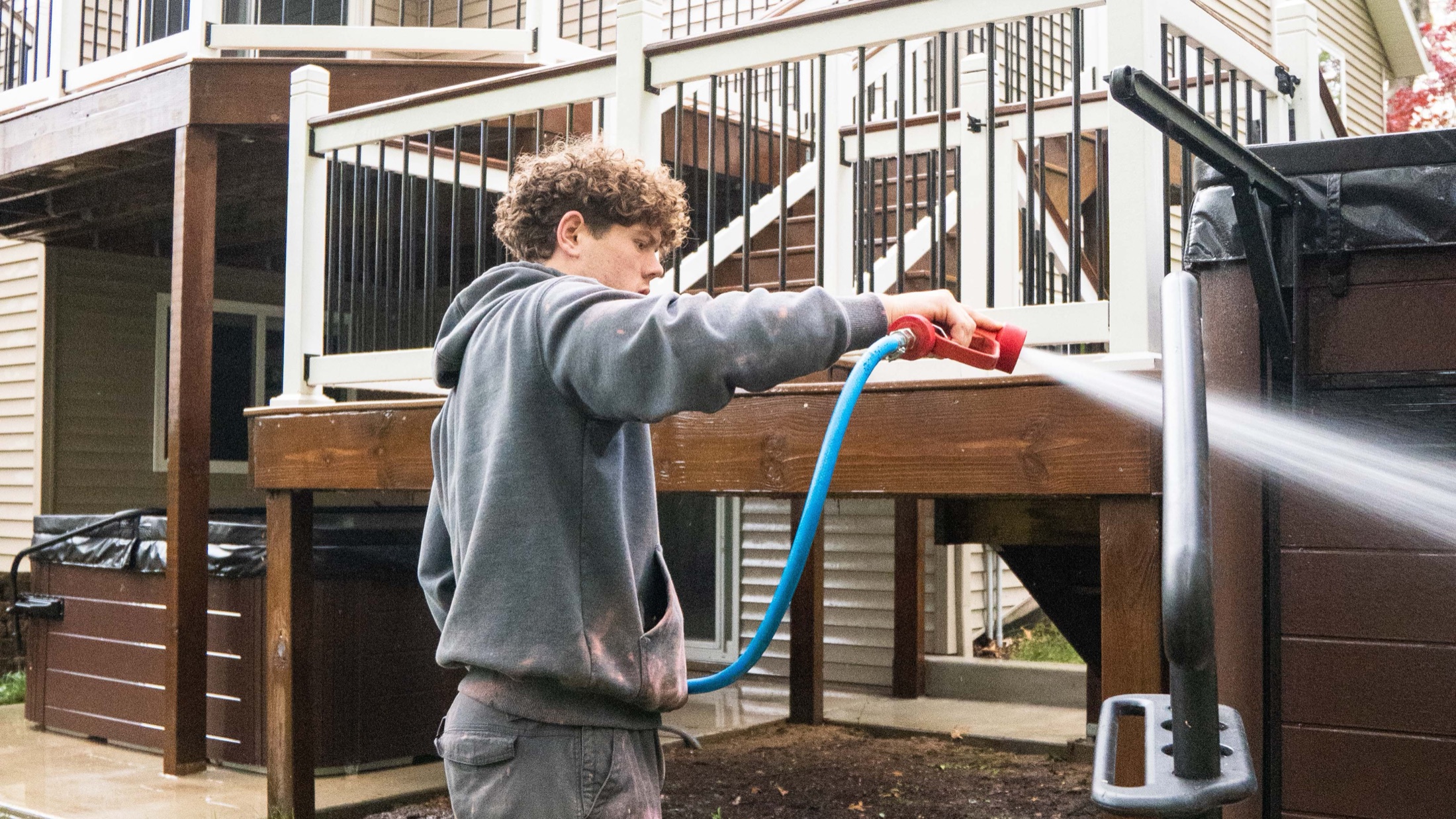 Elevation crew soft-washing a home, deck, and railing in West Michigan